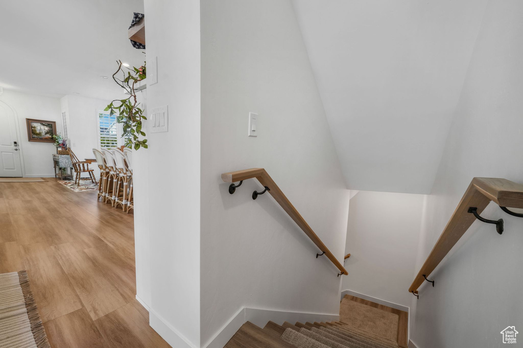 Stairs with wood finished floors and baseboards