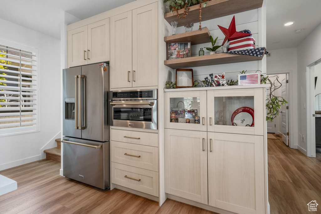 Kitchen featuring stainless steel appliances, light wood finished floors, open shelves, and recessed lighting
