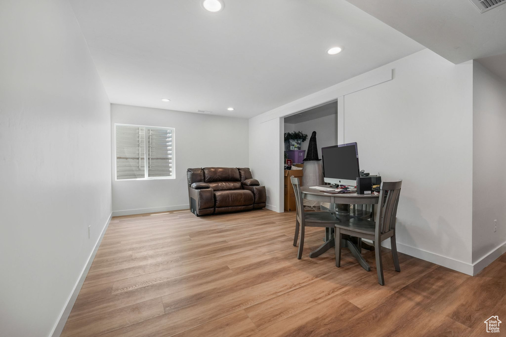 Office space with light wood-style floors and recessed lighting