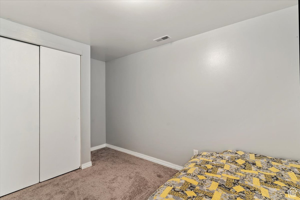 Unfurnished bedroom featuring carpet floors and a closet