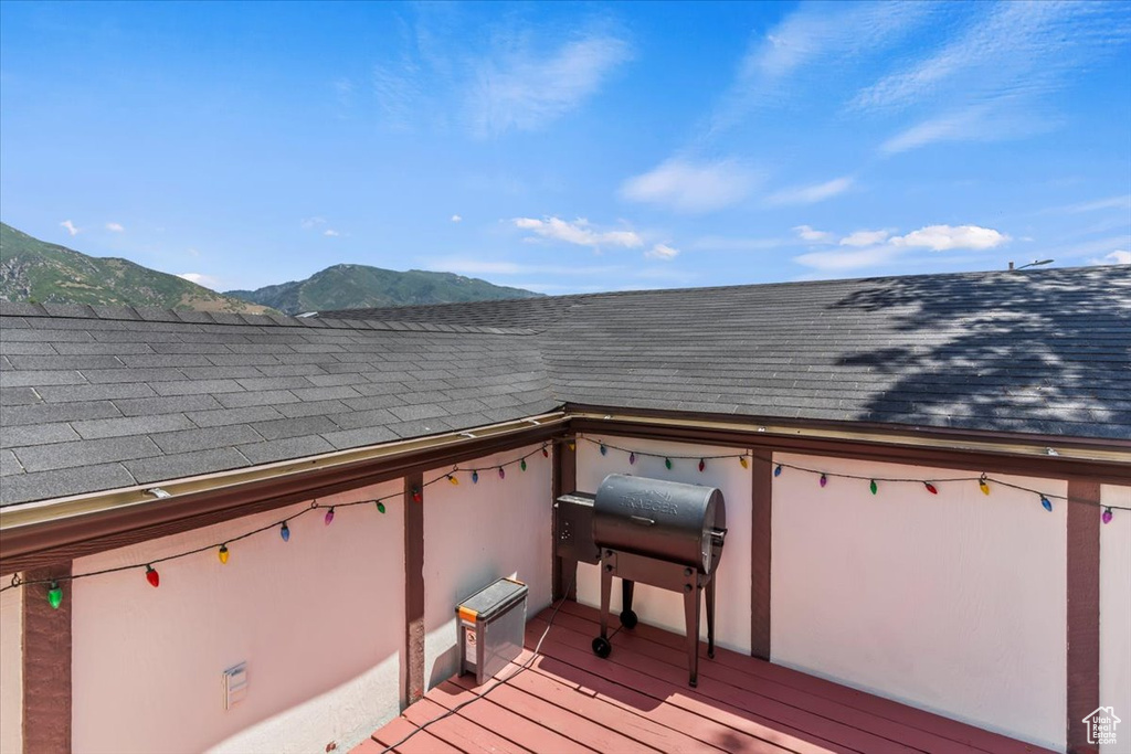 Deck with a mountain view and area for grilling