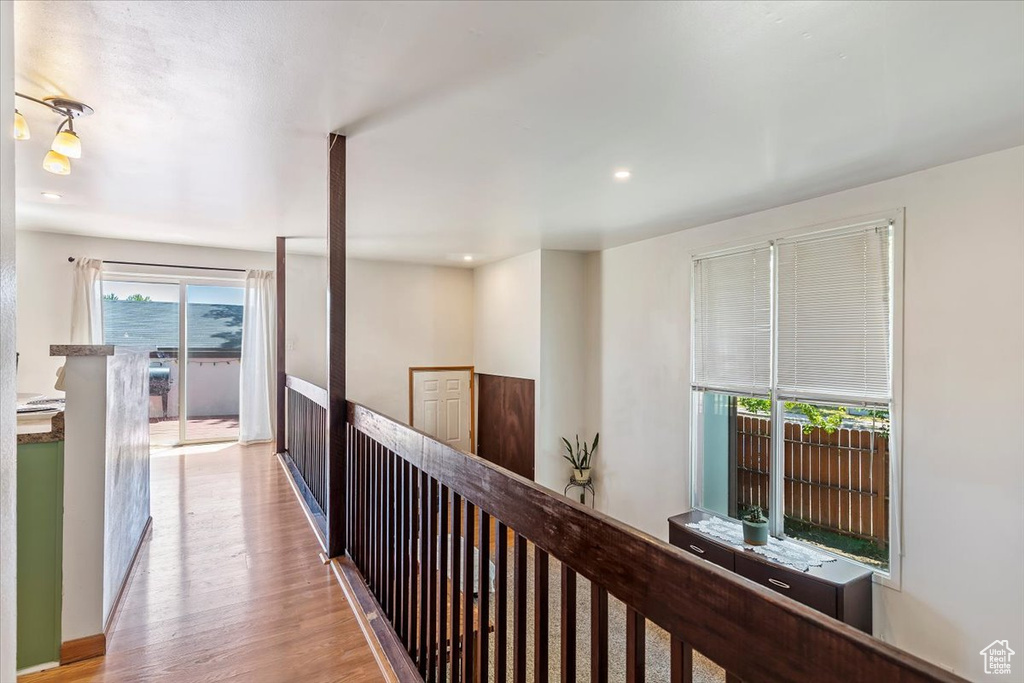 Hall featuring wood finished floors, an upstairs landing, and recessed lighting