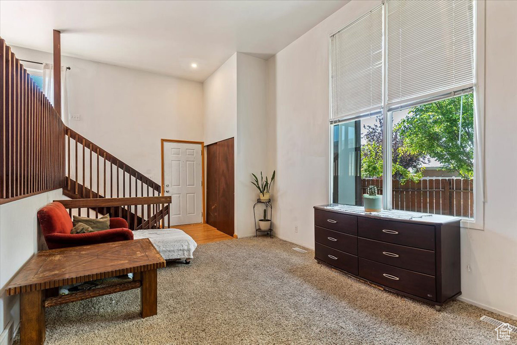 Sitting room with plenty of natural light, carpet flooring, and stairs