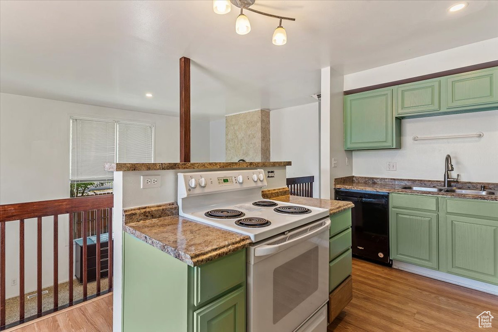 Kitchen with white range with electric cooktop, black dishwasher, green cabinets, light wood-style flooring, and recessed lighting