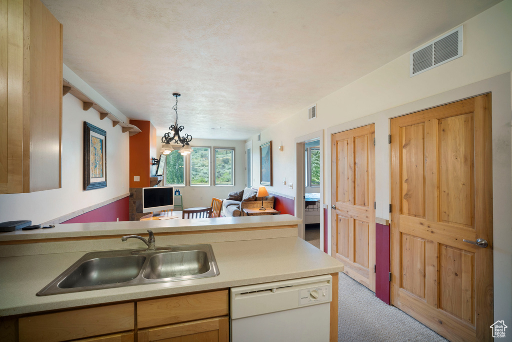 Kitchen featuring dishwasher, carpet floors, open floor plan, light countertops, and pendant lighting