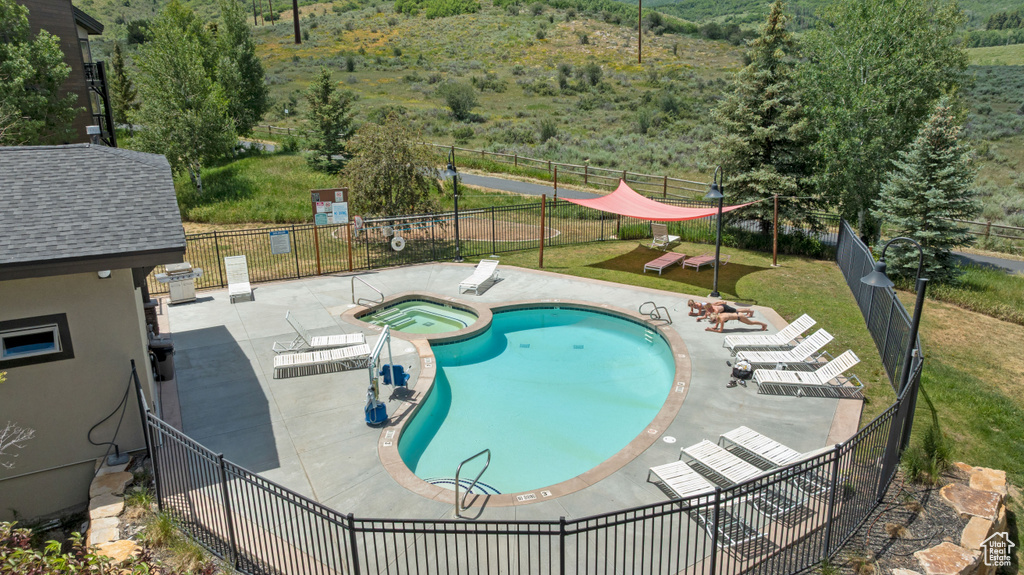 View of pool with a patio area and a pool with connected hot tub
