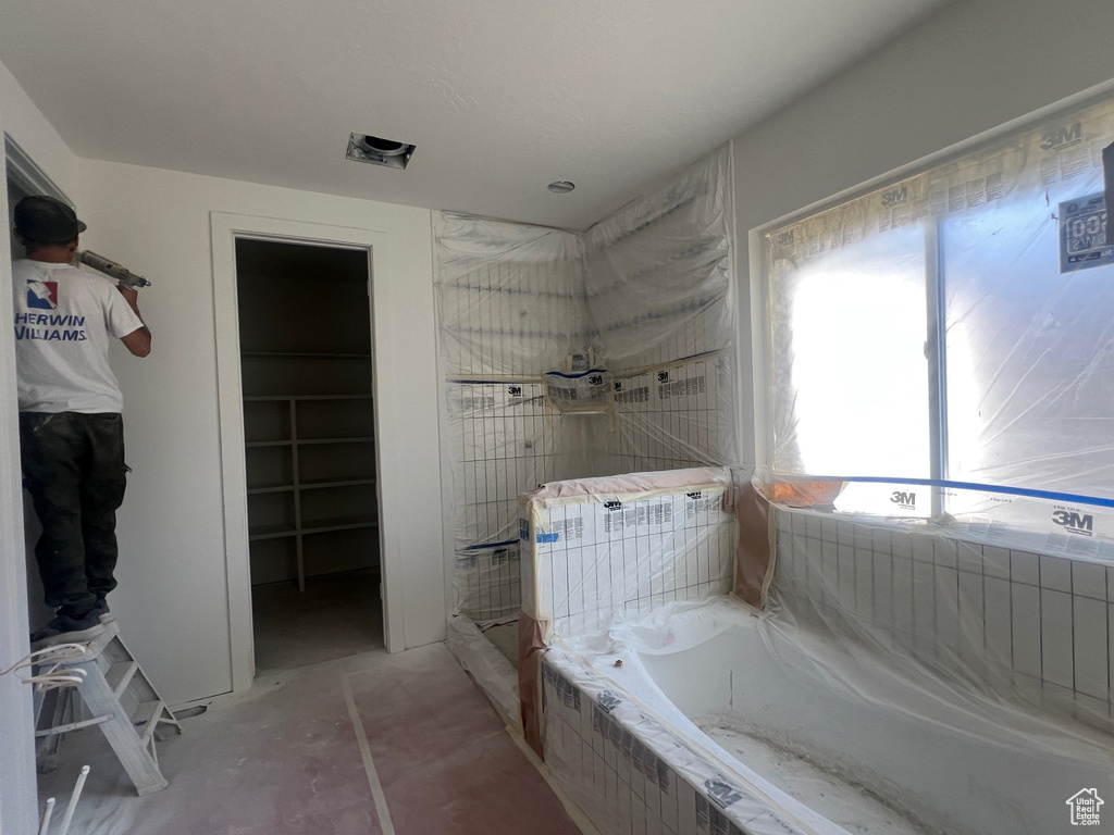 Bathroom featuring a garden tub, a shower, and a walk in closet
