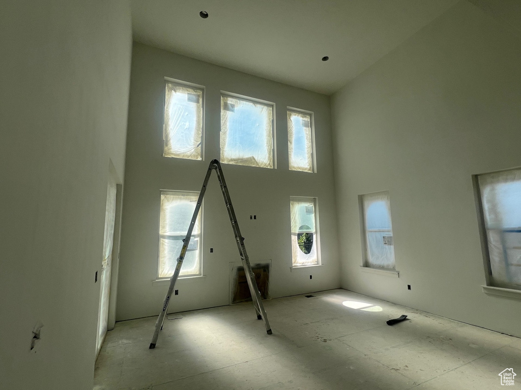 Unfurnished living room with a towering ceiling
