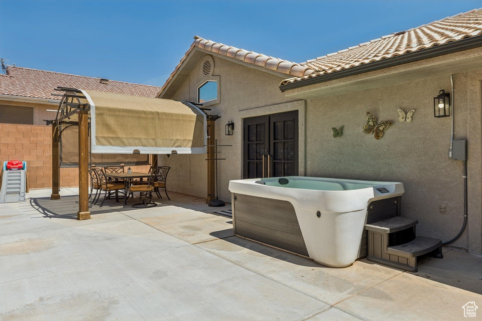 View of patio / terrace featuring a hot tub and outdoor dining area