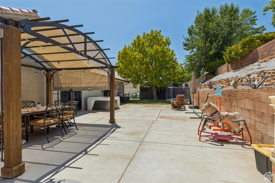 Fenced backyard featuring a pergola, outdoor dining area, and a patio