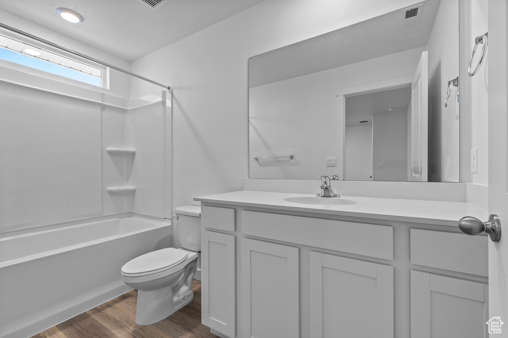 Full bath with vanity, wood finished floors, and washtub / shower combination