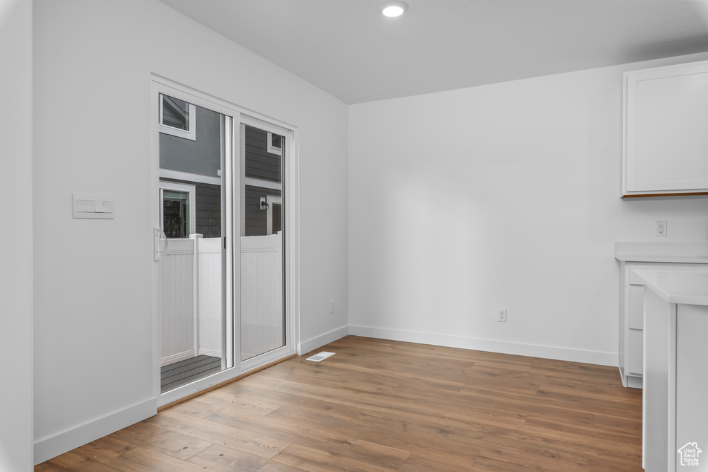 Unfurnished dining area featuring light wood-type flooring and recessed lighting