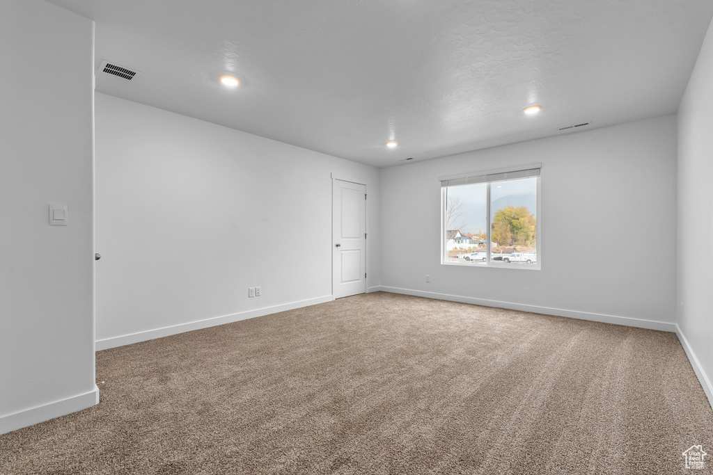 Carpeted empty room featuring recessed lighting