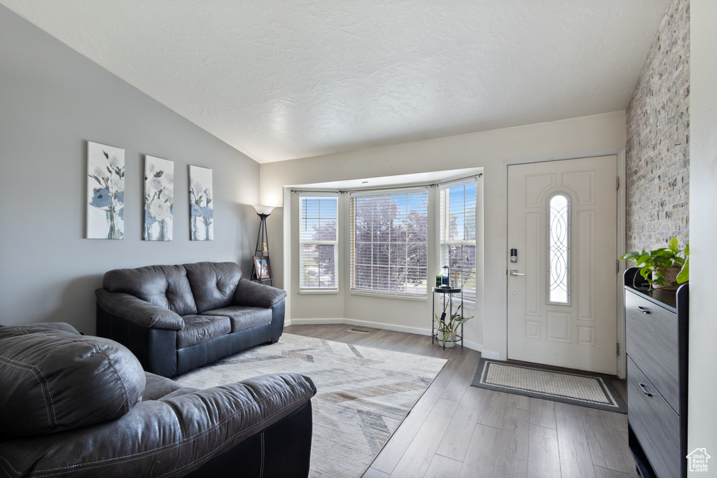 Living room with lofted ceiling and wood finished floors