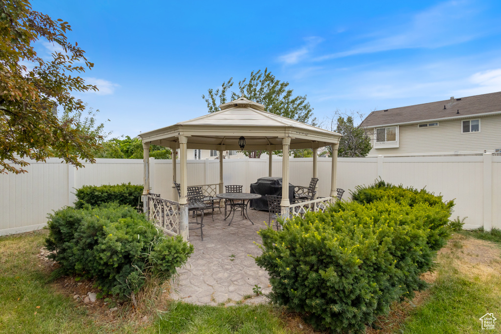Fenced backyard with a gazebo, a patio area, and outdoor dining space