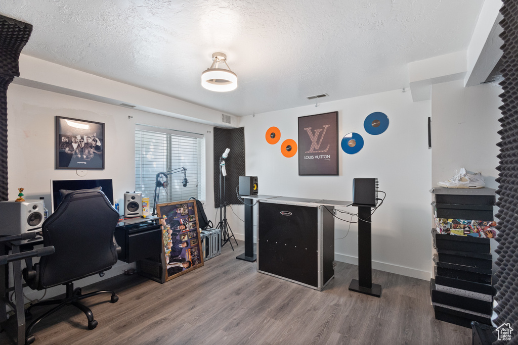 Office space featuring wood finished floors and a textured ceiling