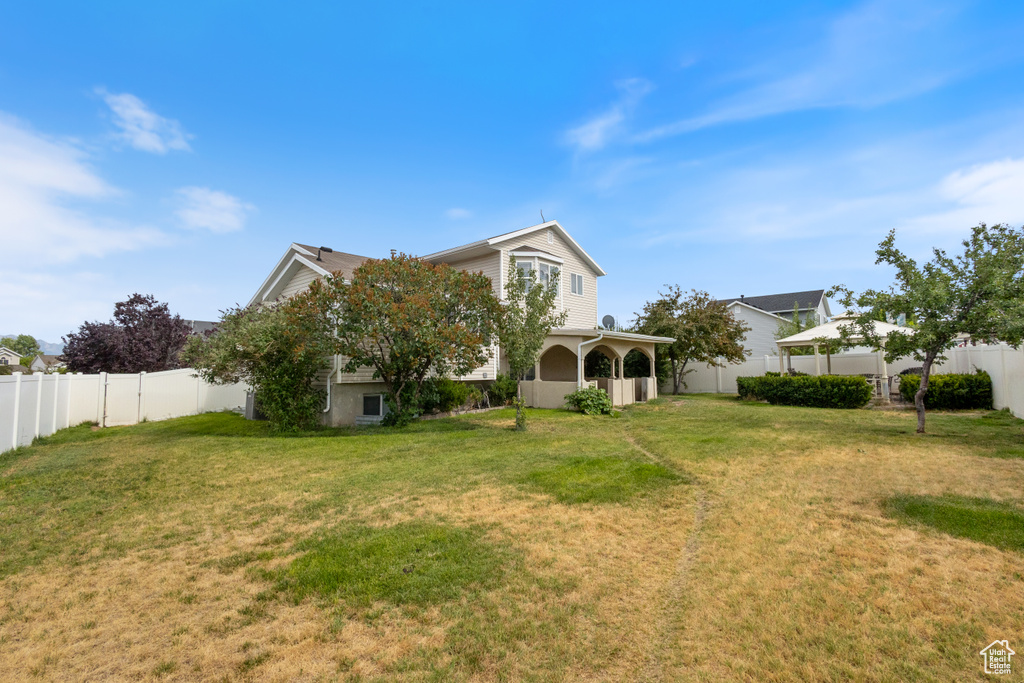 Back of house with a fenced backyard