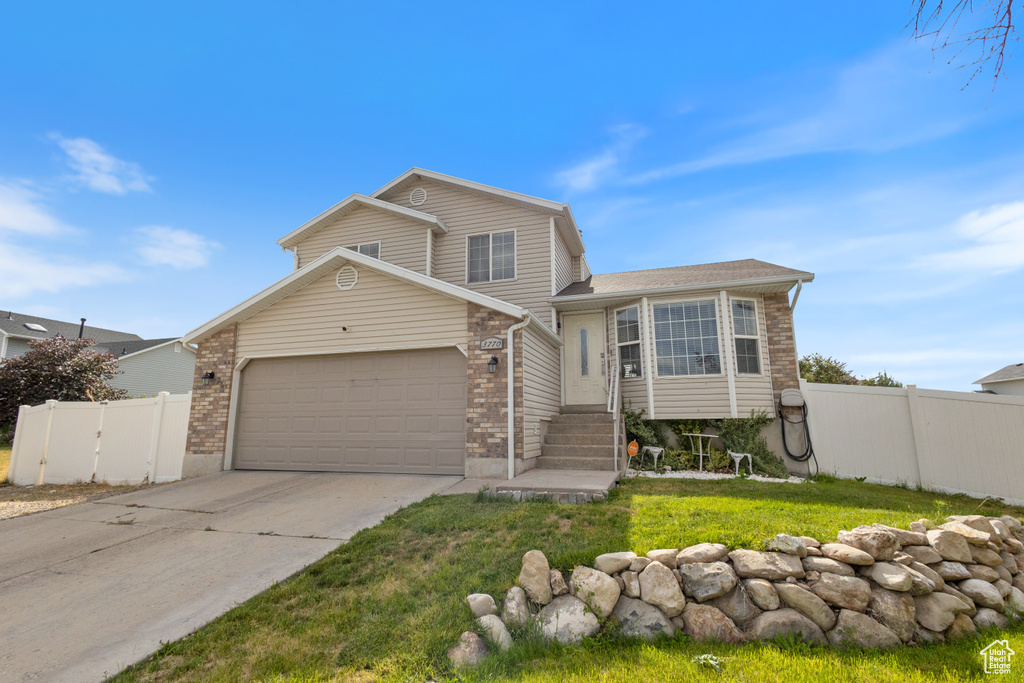 View of front of house with a garage, concrete driveway, and brick siding