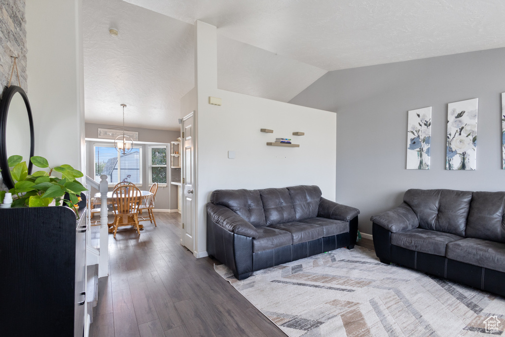 Living area featuring a chandelier, wood finished floors, and lofted ceiling