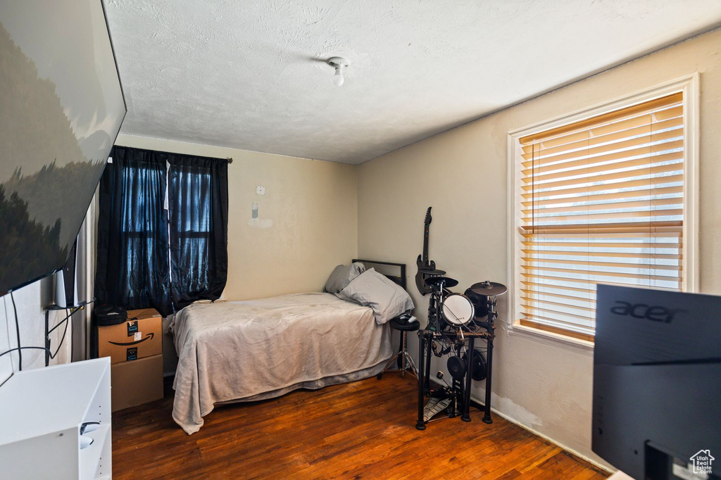 Bedroom featuring wood finished floors and a textured ceiling