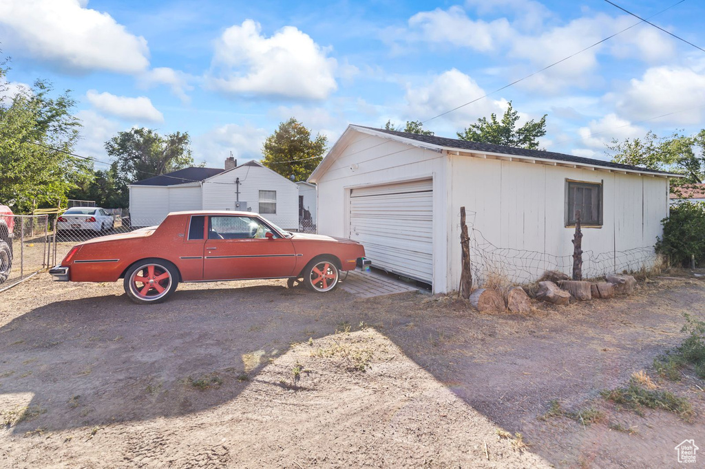 Detached garage featuring dirt driveway