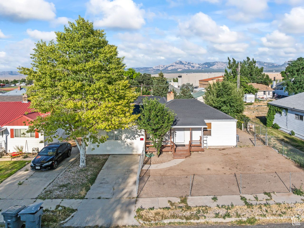 View of front of property with a mountain view, driveway, a chimney, and entry steps