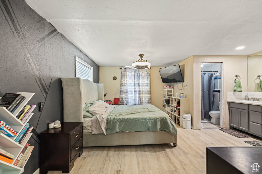 Bedroom featuring light wood finished floors and ensuite bathroom