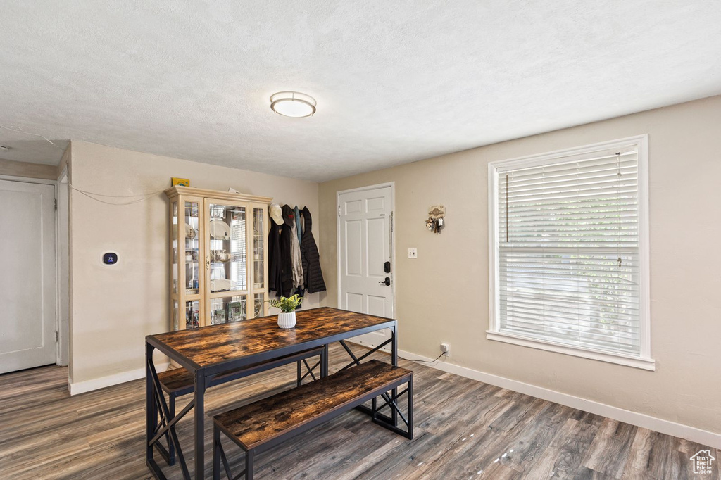 Dining space with dark wood-style floors and a textured ceiling