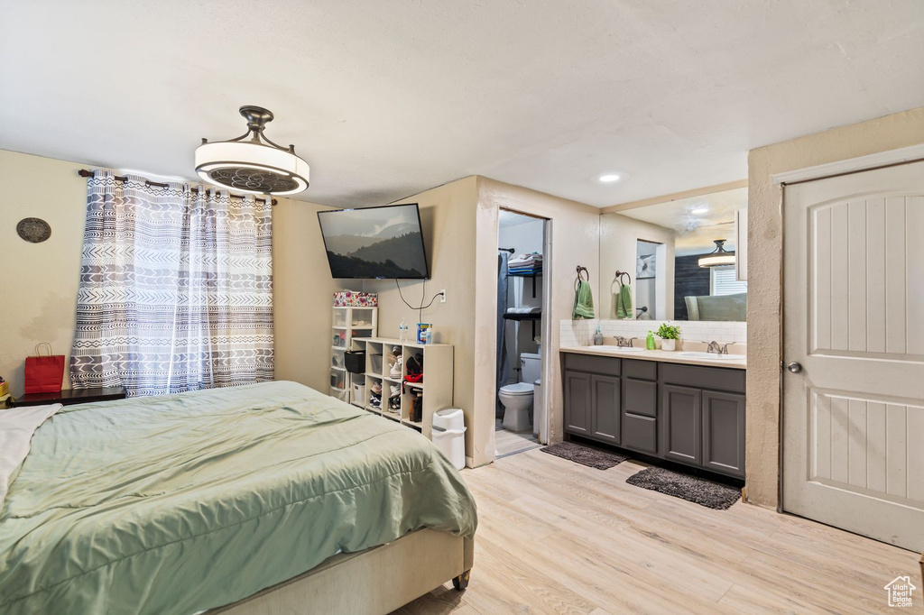 Bedroom with light wood-style flooring and ensuite bathroom
