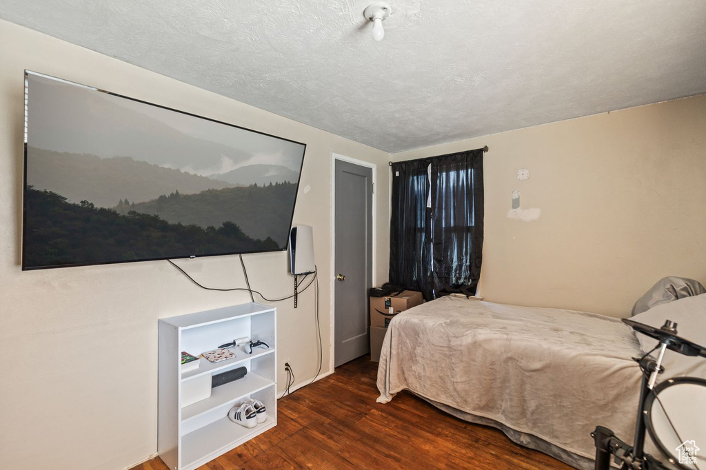 Bedroom featuring wood finished floors and a textured ceiling
