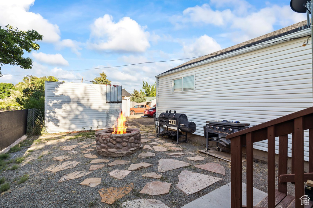 View of patio featuring a fire pit, a grill, and an outdoor structure
