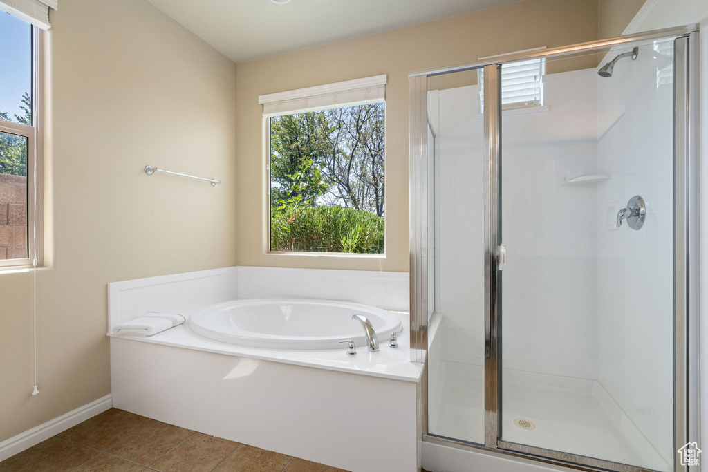 Full bath featuring a stall shower, plenty of natural light, a garden tub, and tile patterned floors