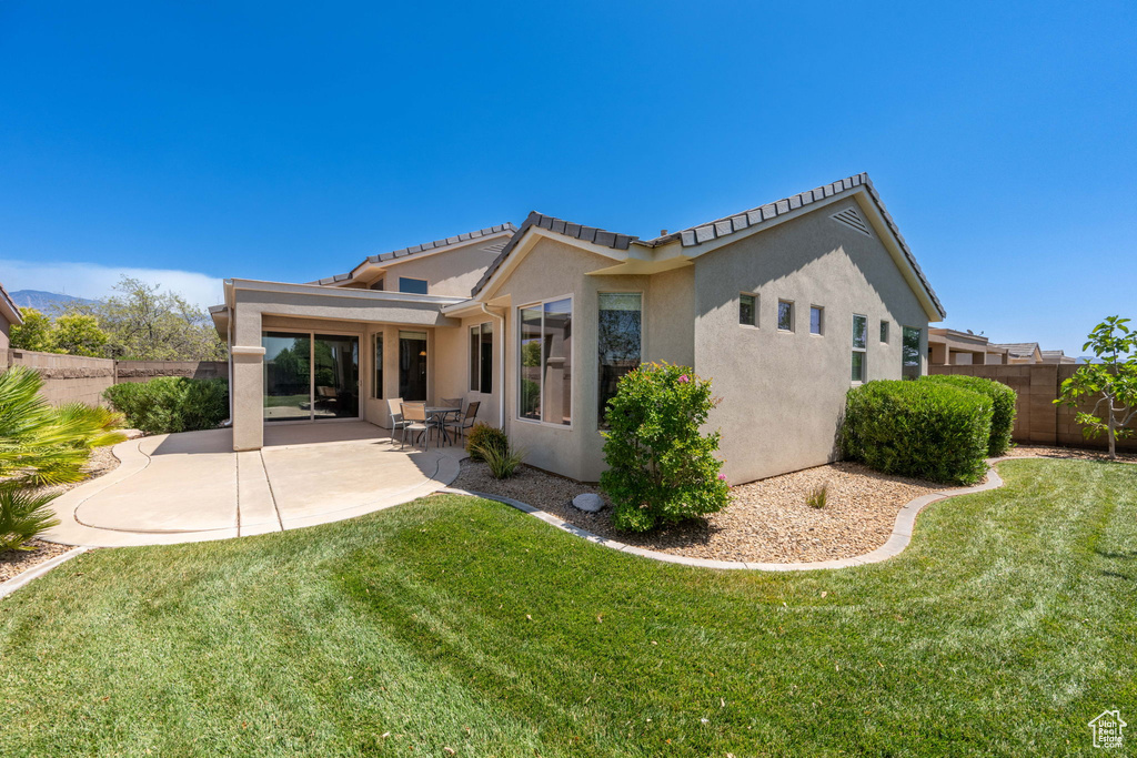 Back of house featuring stucco siding, a fenced backyard, a patio, and a tiled roof