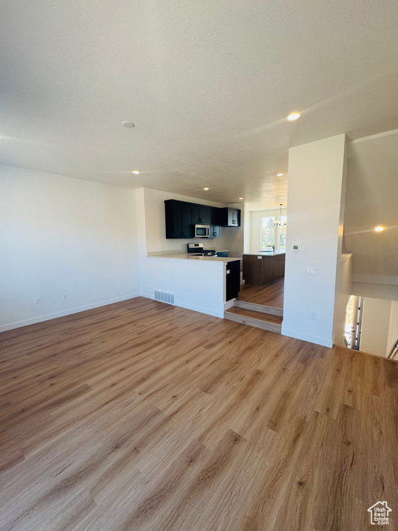 Unfurnished living room with light wood finished floors and recessed lighting