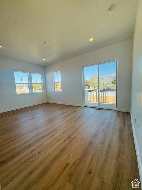 Spare room with wood finished floors, recessed lighting, and a smoke detector