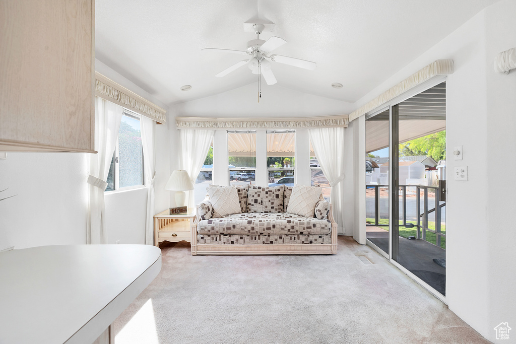 Sunroom / solarium featuring carpet floors, lofted ceiling, and healthy amount of natural light