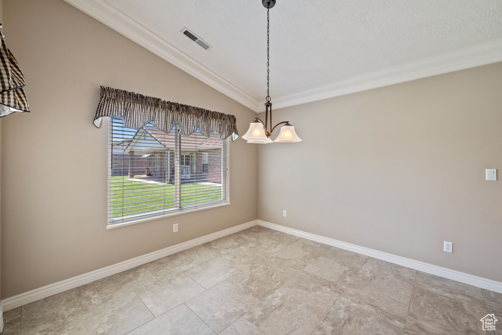 Unfurnished room featuring vaulted ceiling and crown molding