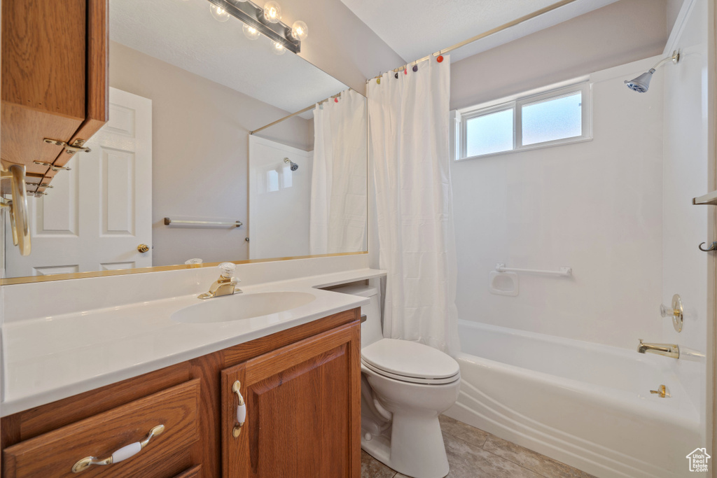 Full bath with vanity, shower / tub combo with curtain, and tile patterned floors