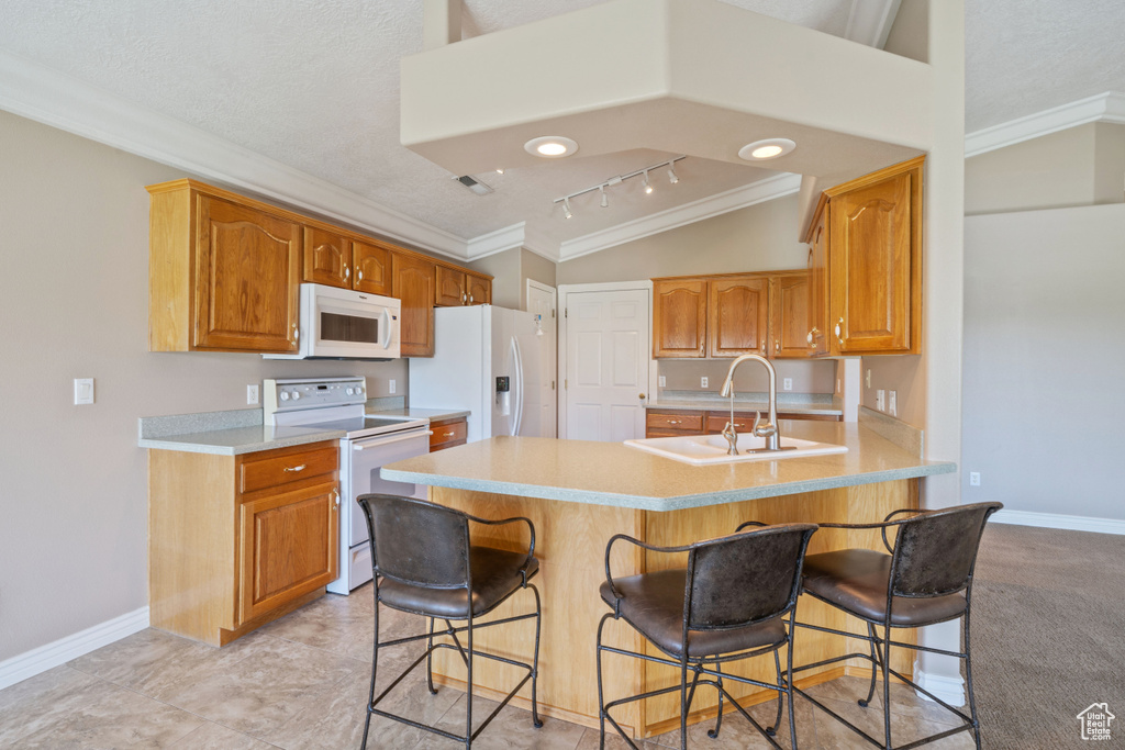 Kitchen with white appliances, crown molding, a peninsula, a kitchen breakfast bar, and light countertops