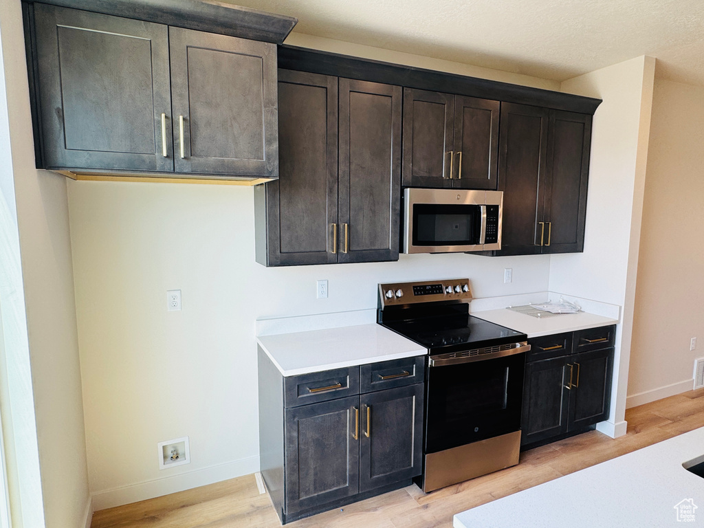 Kitchen featuring stainless steel appliances, light wood-style flooring, and light countertops