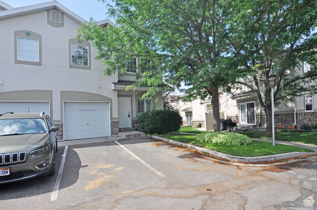 View of front of property featuring stone siding, stucco siding, and a garage