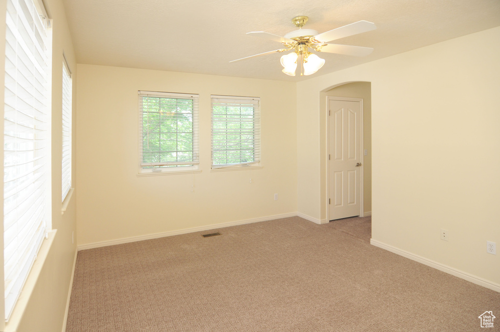 Spare room with light carpet and ceiling fan
