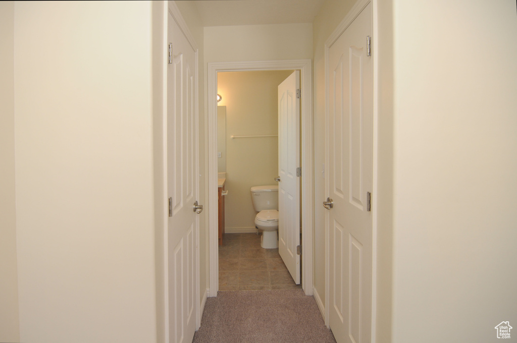 Hallway featuring light colored carpet