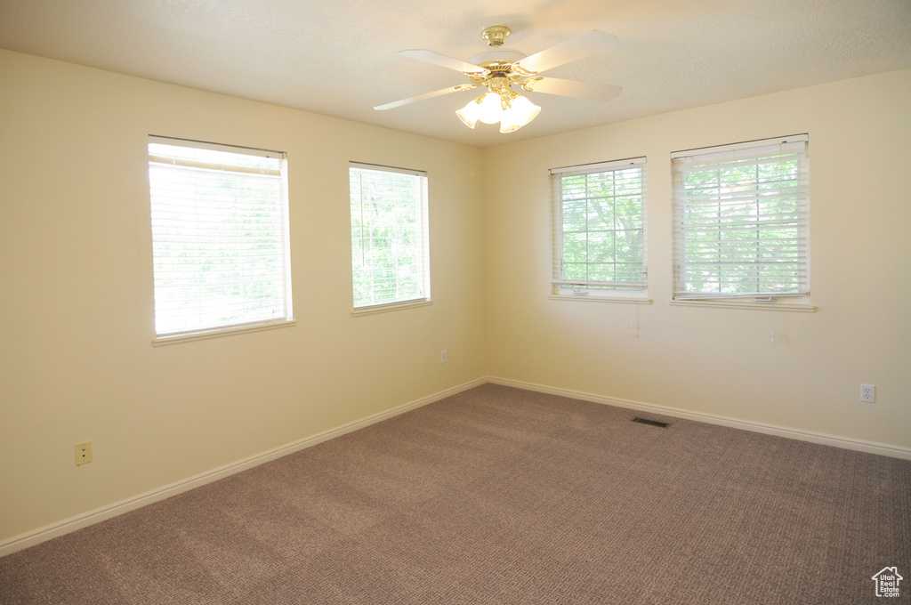 Carpeted empty room with baseboards and ceiling fan