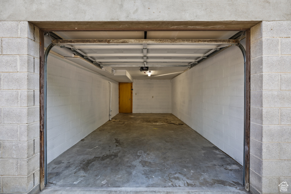 Garage featuring concrete block wall and a garage door opener