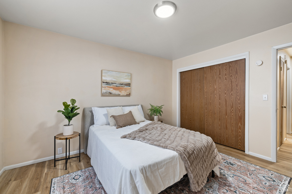 Bedroom with wood finished floors and a closet