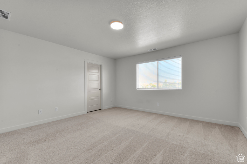 Empty room featuring light colored carpet