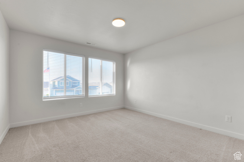 Spare room featuring baseboards and light colored carpet