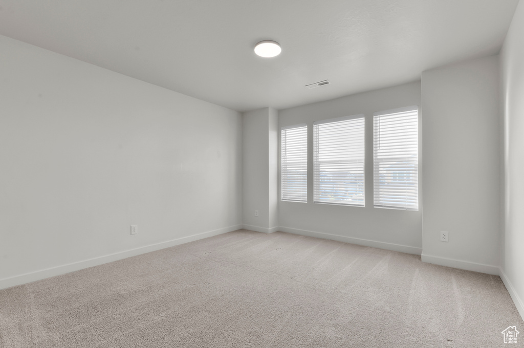 Empty room with baseboards and light carpet
