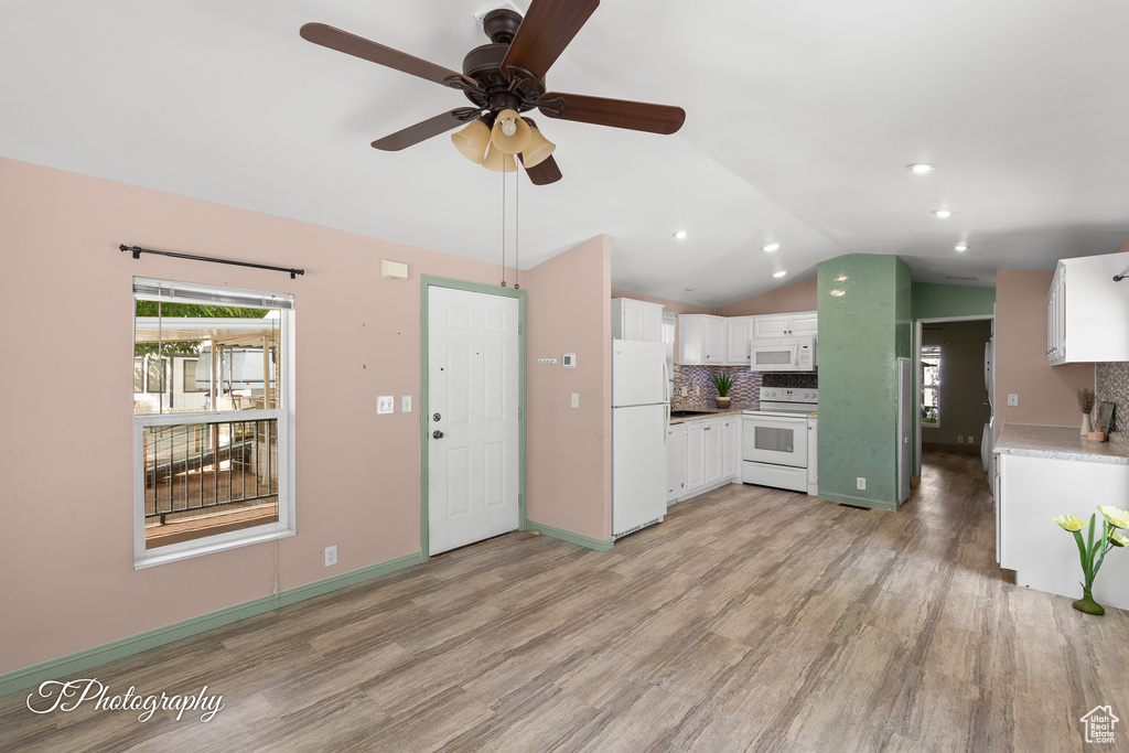Unfurnished living room with lofted ceiling, light wood-style floors, and a ceiling fan